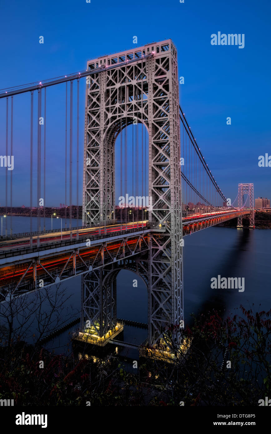 Entrambe le torri e i montanti con luci auto striature thru il Ponte George Washington Bridge durante le ore di colore blu. Foto Stock