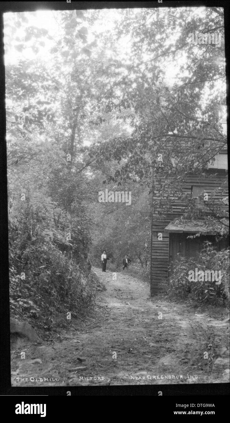 Questa fotografia d'epoca cattura due individui vicino al vecchio mulino a Milford, Ohio, mostrando un tranquillo paesaggio rurale e lo stile di vita rurale tipico degli inizi del XX secolo negli Stati Uniti Foto Stock