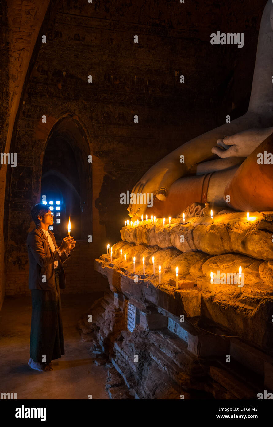 BAGAN, MYANMAR - CIRCA NEL DICEMBRE 2013: Pellegrino pagando tributo a Buda nel Pahto Thamya tempio di Bagan Foto Stock