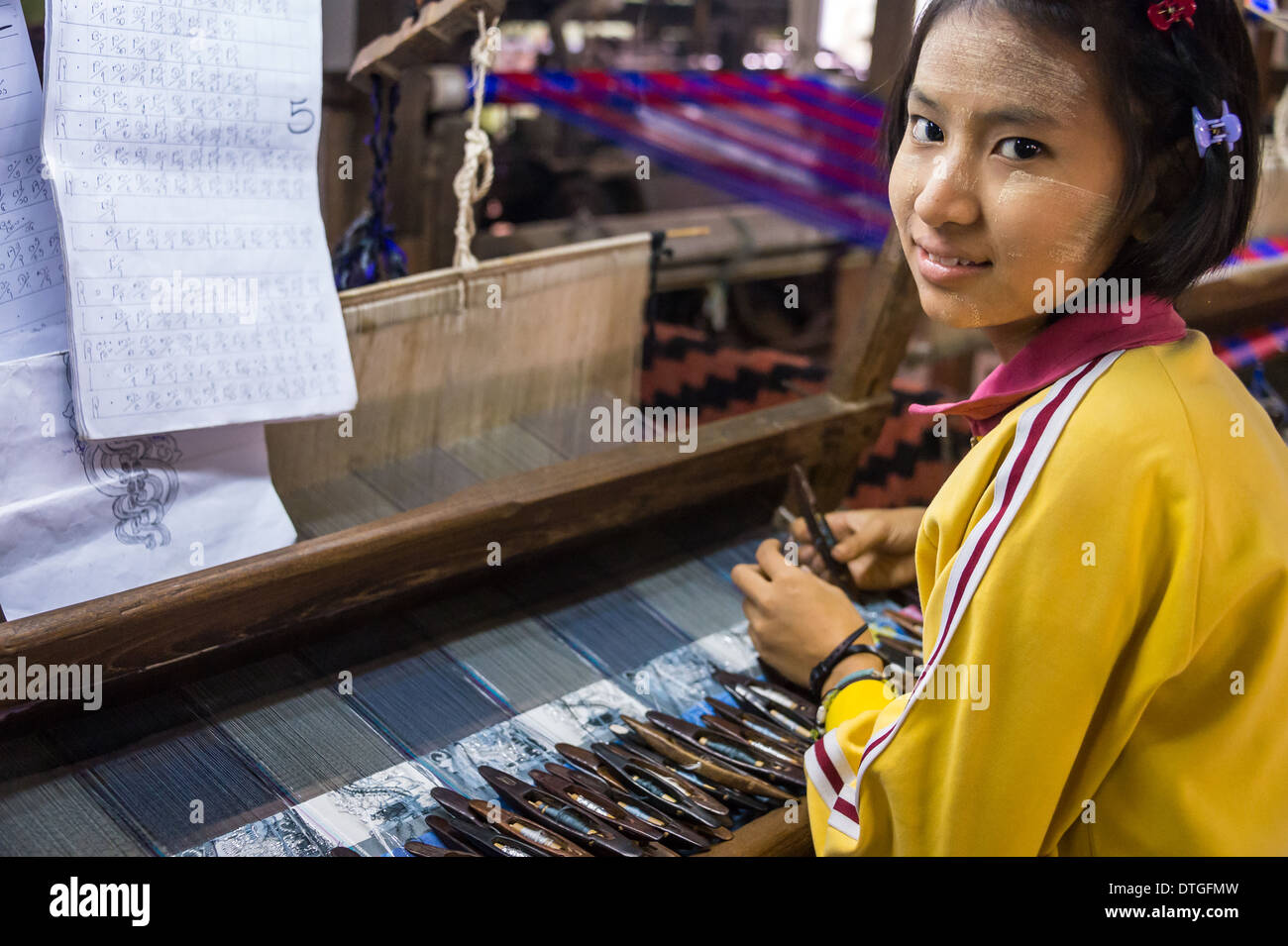 Giovane donna webing di lavoro tipici tessuti birmani in Amarpura in Myanmar Foto Stock