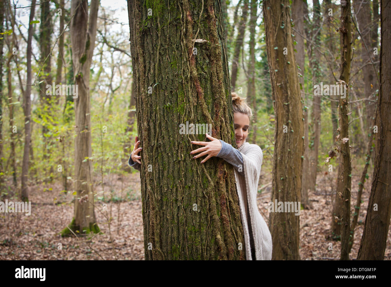 Donna che abbraccia un albero Foto Stock