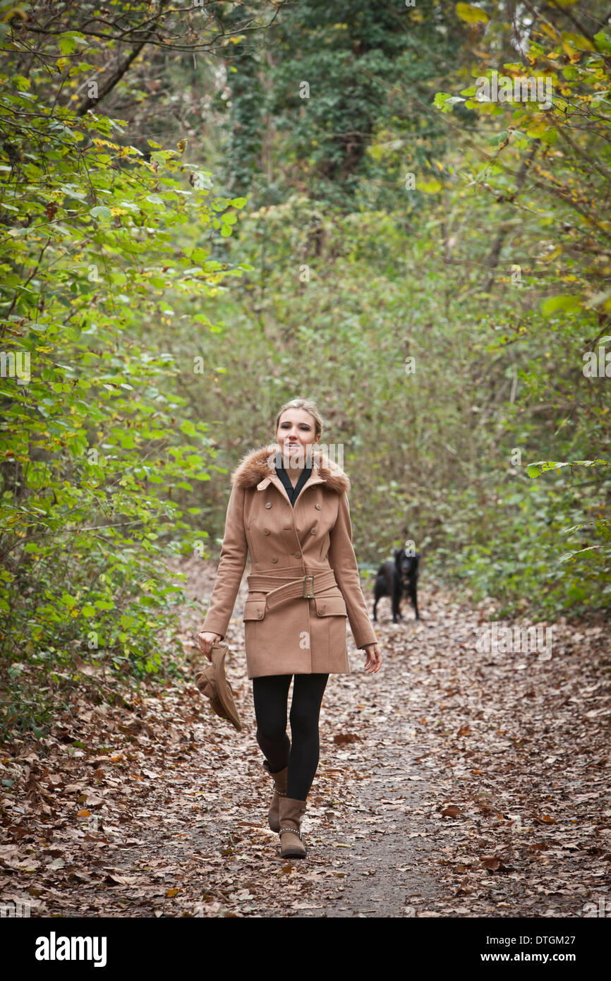 Donna che cammina in una foresta Foto Stock