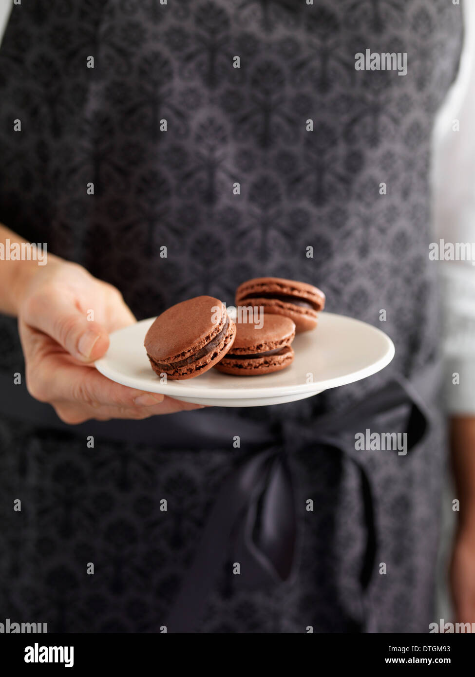 Persona in possesso di una piastra di amaretti Foto Stock