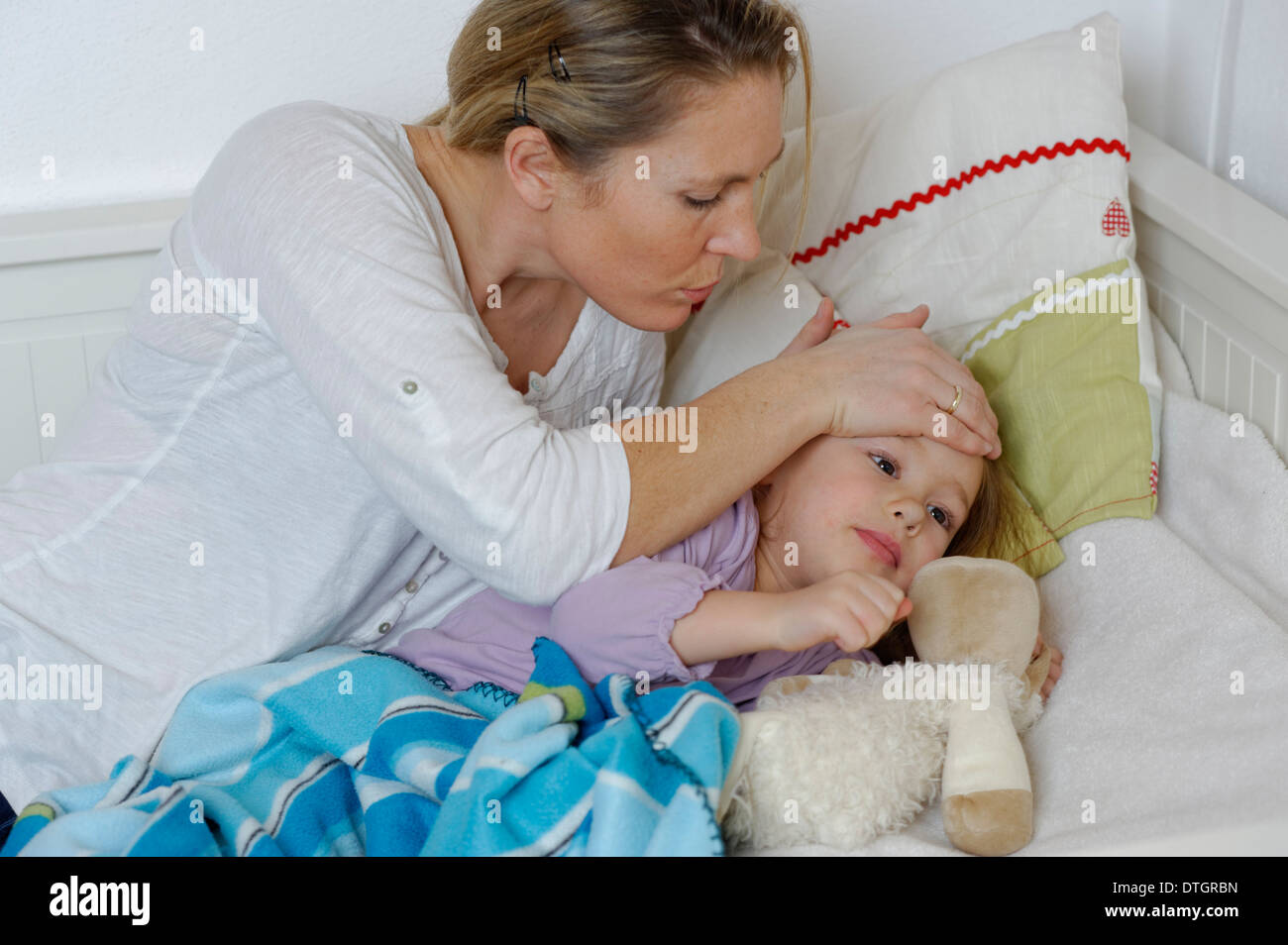 Madre di prendersi cura di sua figlia malata, bambino giacente a letto Foto Stock