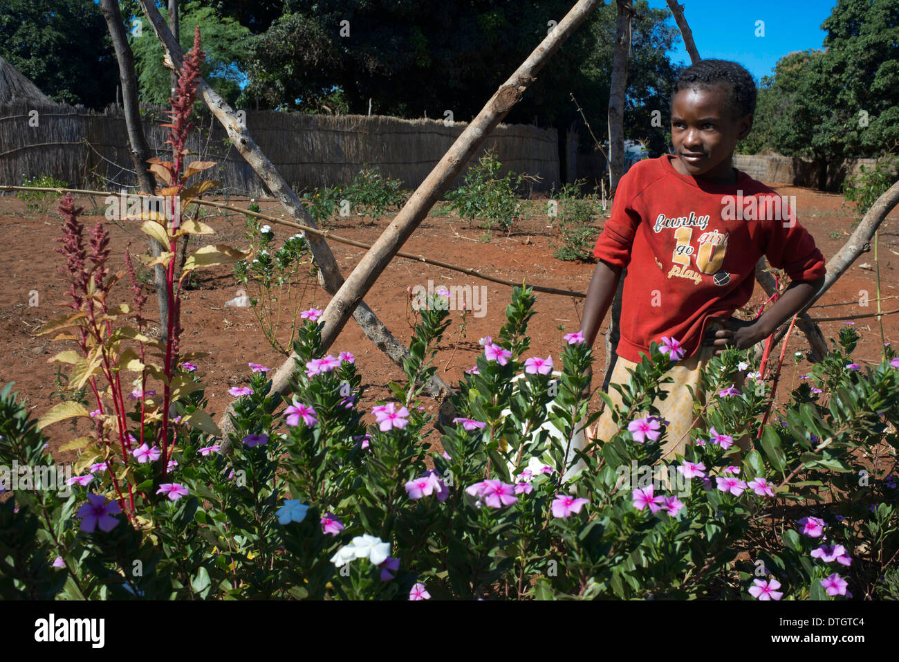 Una ragazza nel suo giardino nel villaggio Mukuni. La corrente Mukuni Village si trova a soli sette chilometri da Victoria Falls Foto Stock