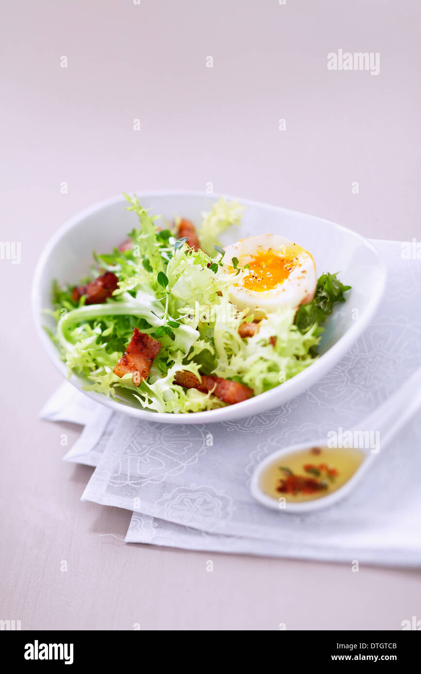 Curly insalata riccia con la pancetta tagliata a dadini e soft-uovo sodo Foto Stock