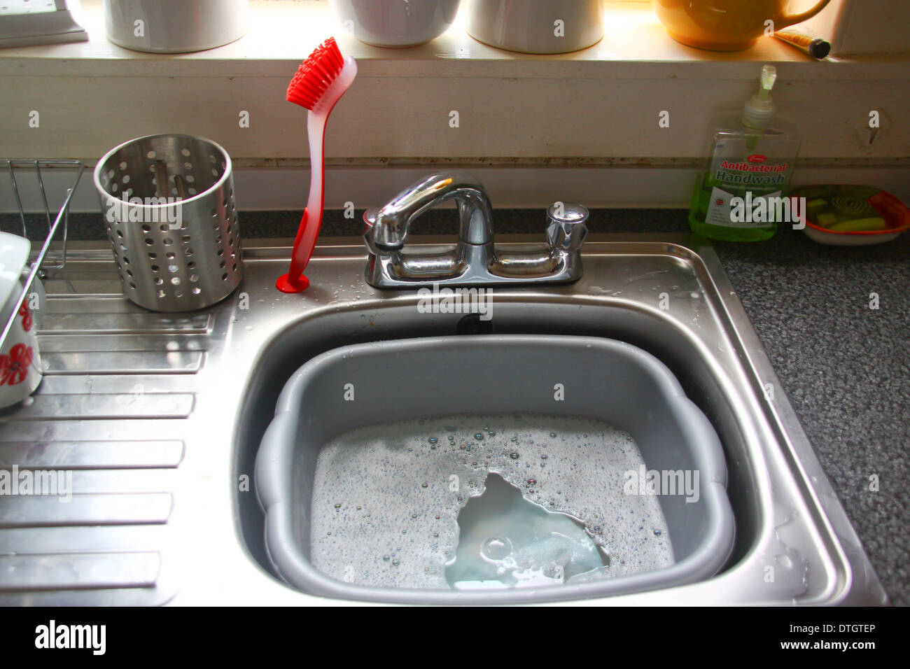 Acciaio inox lavello da cucina con bacinella di plastica Foto Stock