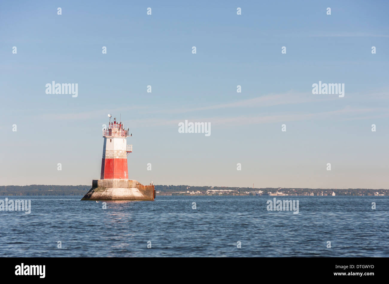 Grande colore bianco e rosso segno marini o beacon o un faro in mare. Bird sedersi sulla parte superiore del faro. Foto Stock