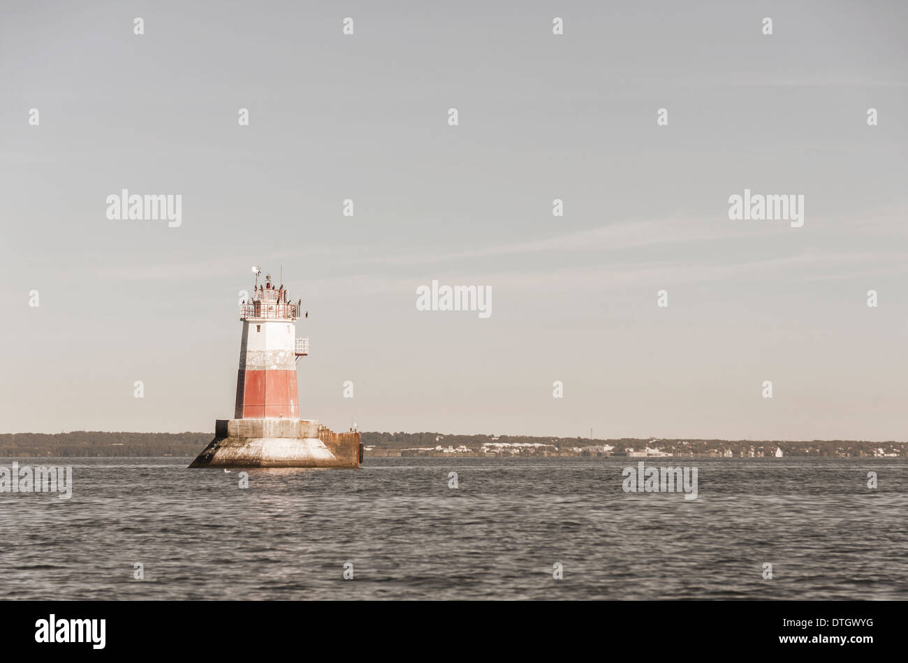 Grande colore bianco e rosso segno marini o beacon o un faro in mare. Bird sedersi sulla parte superiore del faro. Foto Stock