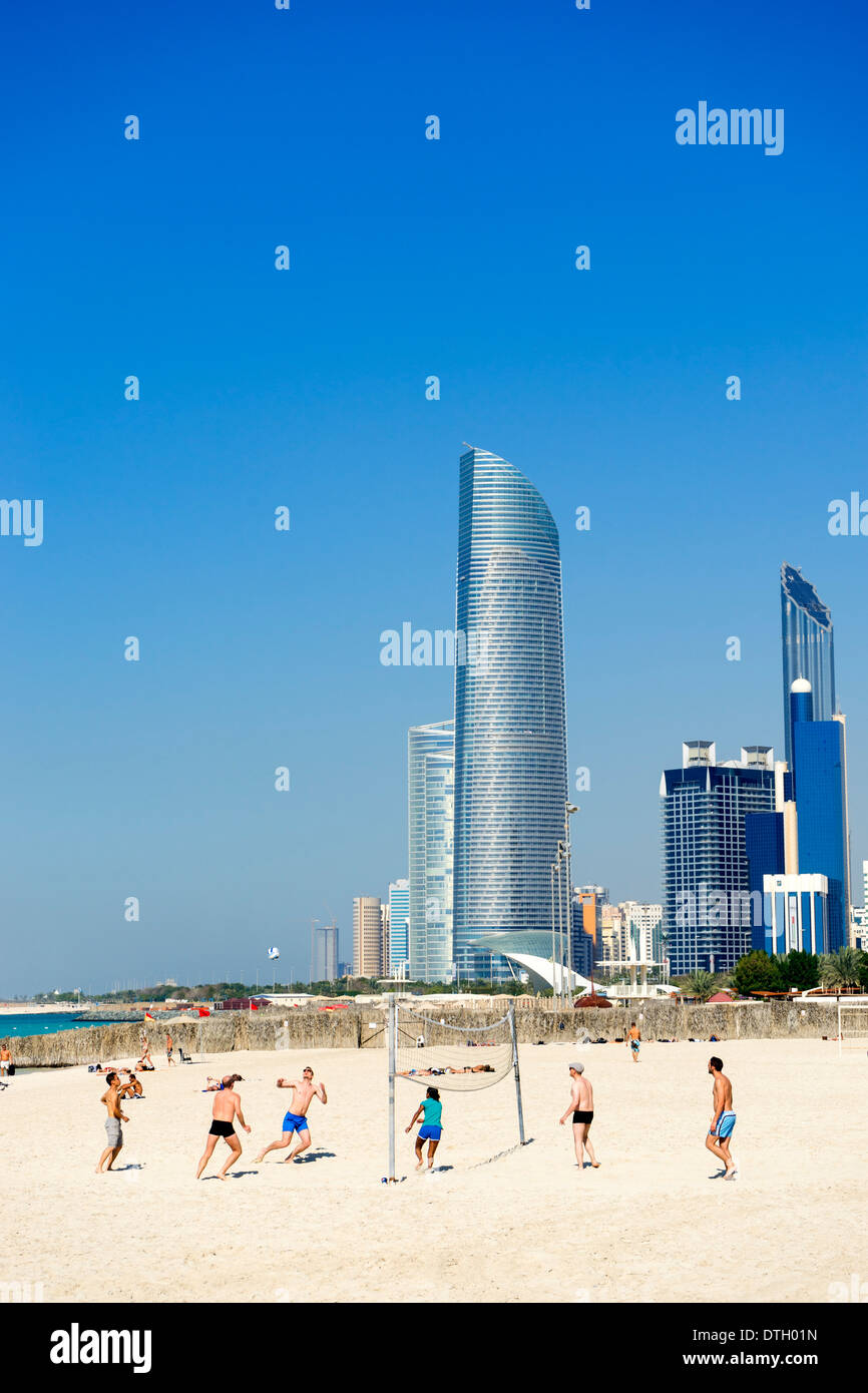 Partita di pallavolo sulla spiaggia di Corniche con skyline di Abu Dhabi Emirati arabi uniti Foto Stock
