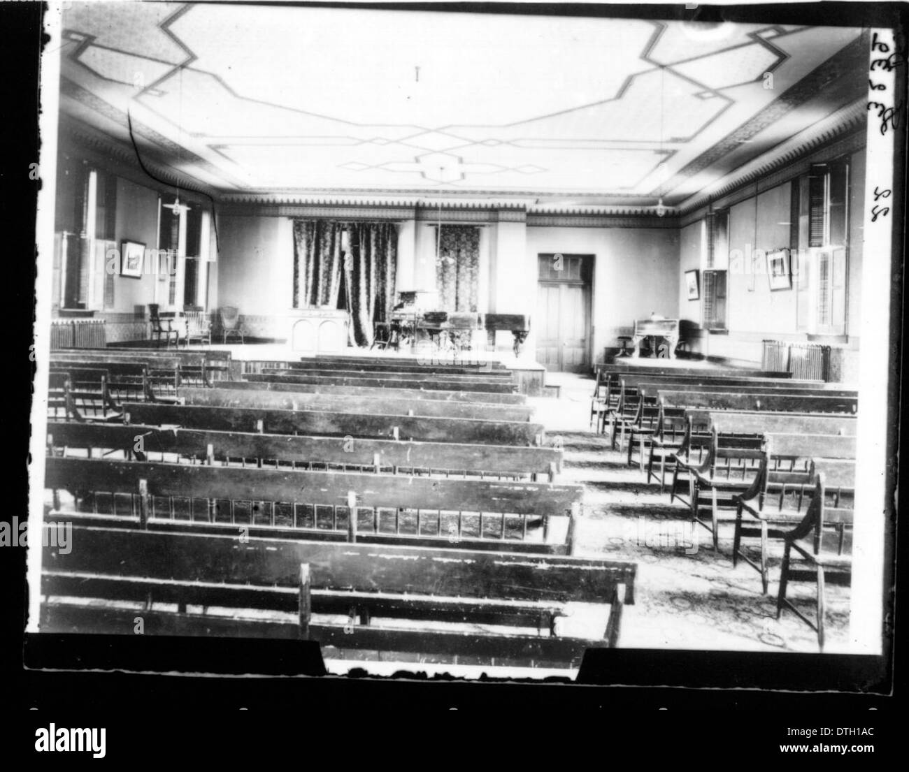 Questa fotografia non datata mostra l'interno di un auditorium universitario, con file di panche, strumenti musicali e un pianoforte a coda sul palco. L'ambiente riflette l'ambiente culturale e accademico dell'università. Foto Stock