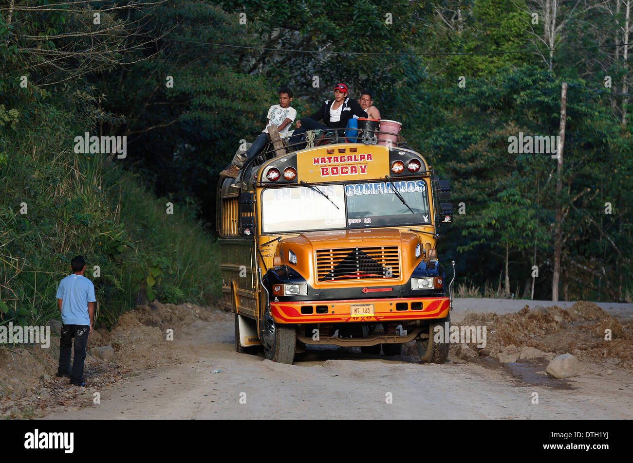 Persone a cavallo sul tetto di un autobus gialli, Penas Blancas, Nicaragua Foto Stock