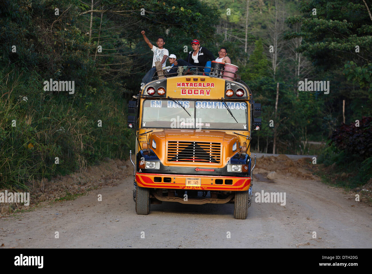 Persone a cavallo sul tetto di un autobus gialli, Penas Blancas, Nicaragua Foto Stock