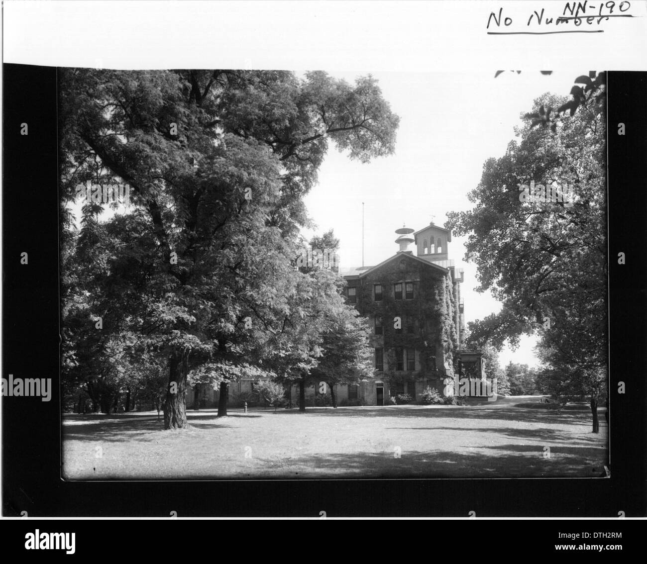 Questa fotografia fornisce una vista parzialmente oscurata di Peabody Hall, un edificio iconico della Miami University di Oxford, Ohio. L'immagine fa parte della collezione digitale dell'università, che mostra l'architettura storica e il significato accademico del campus. Foto Stock
