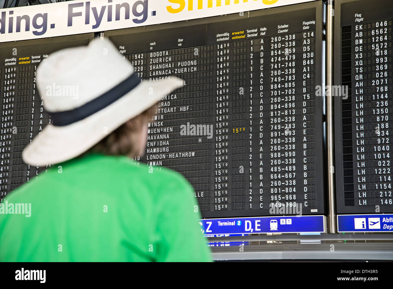 Adolescente guardando un display board nell'aeroporto di Francoforte. Foto Stock