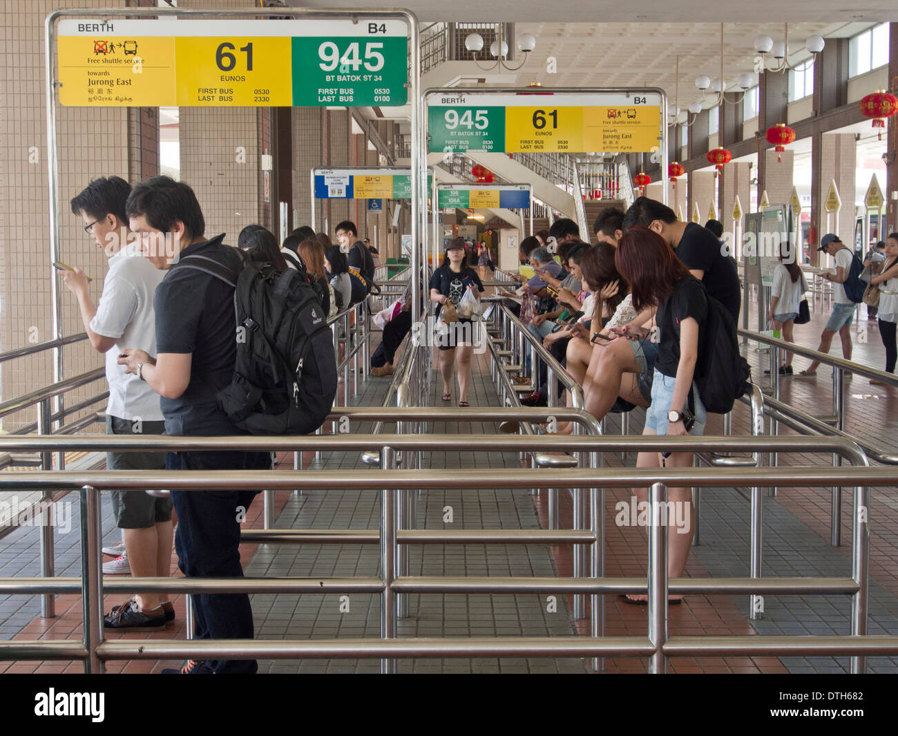 La gente in una coda ordinata alla stazione degli autobus in Singapore Foto Stock