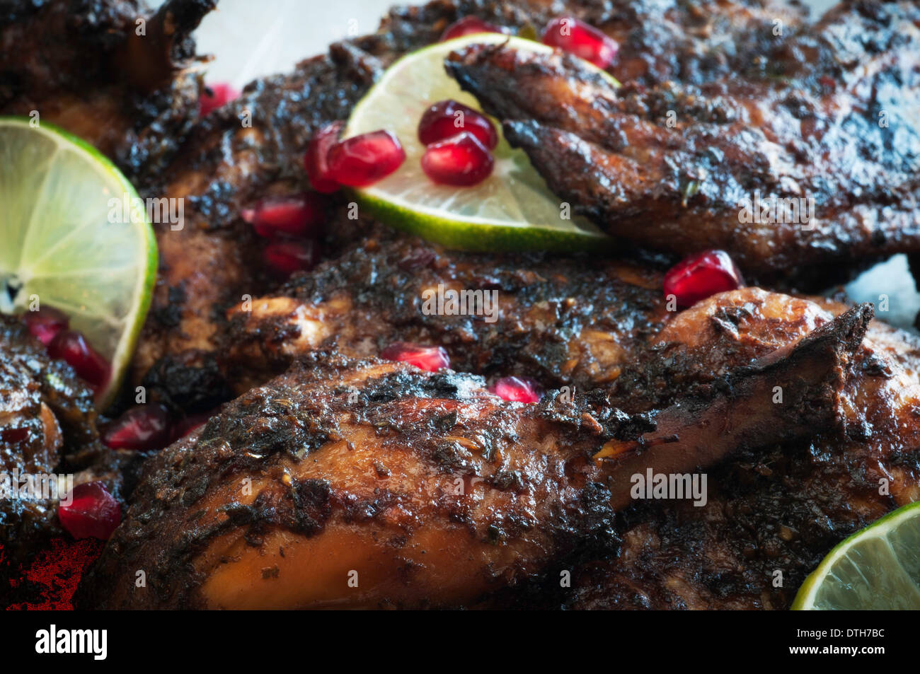 Piatto di pollo arrosto con salsa di jerk, melograno, calce e guarnire erbe Foto Stock