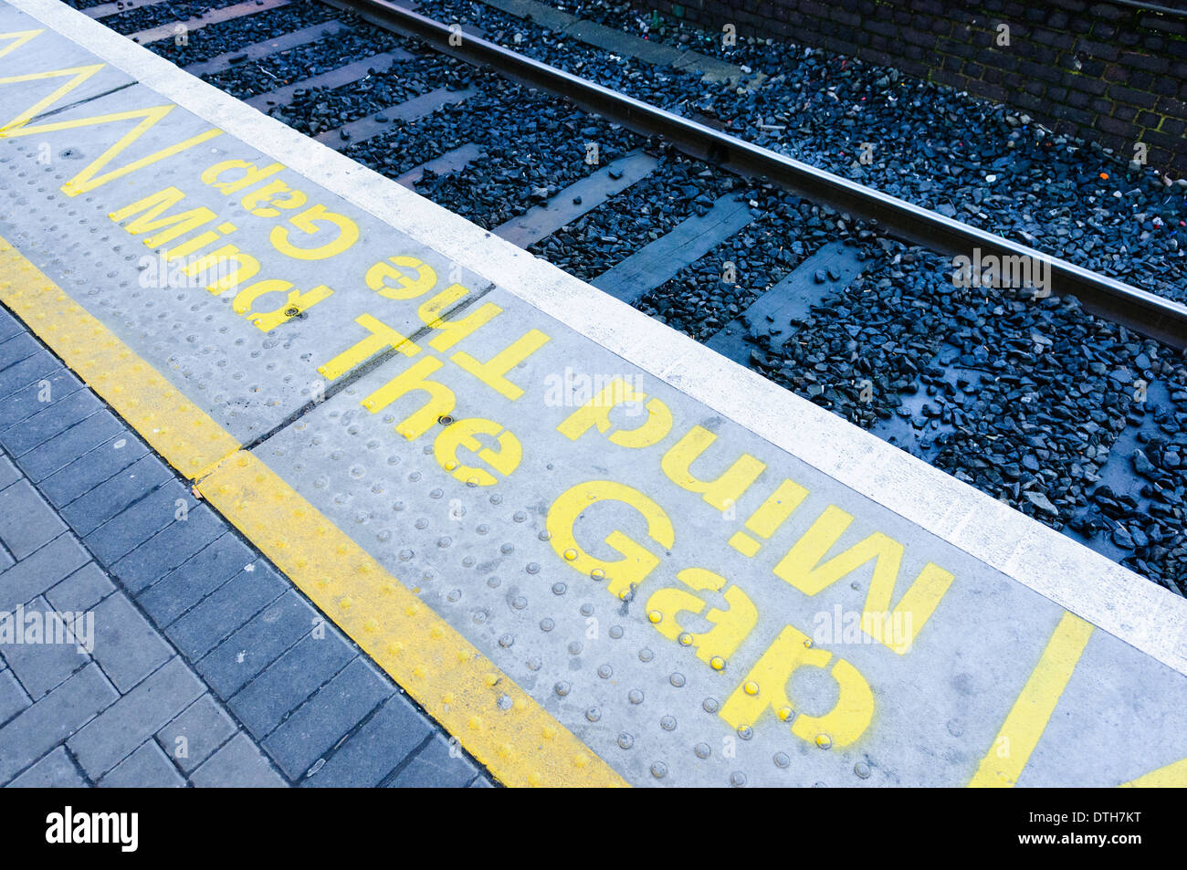 'Mind Gap" contrassegni su una piattaforma ferroviaria Foto Stock