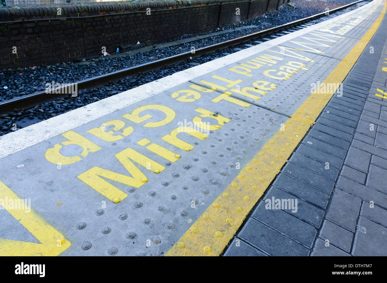 'Mind Gap" contrassegni su una piattaforma ferroviaria Foto Stock