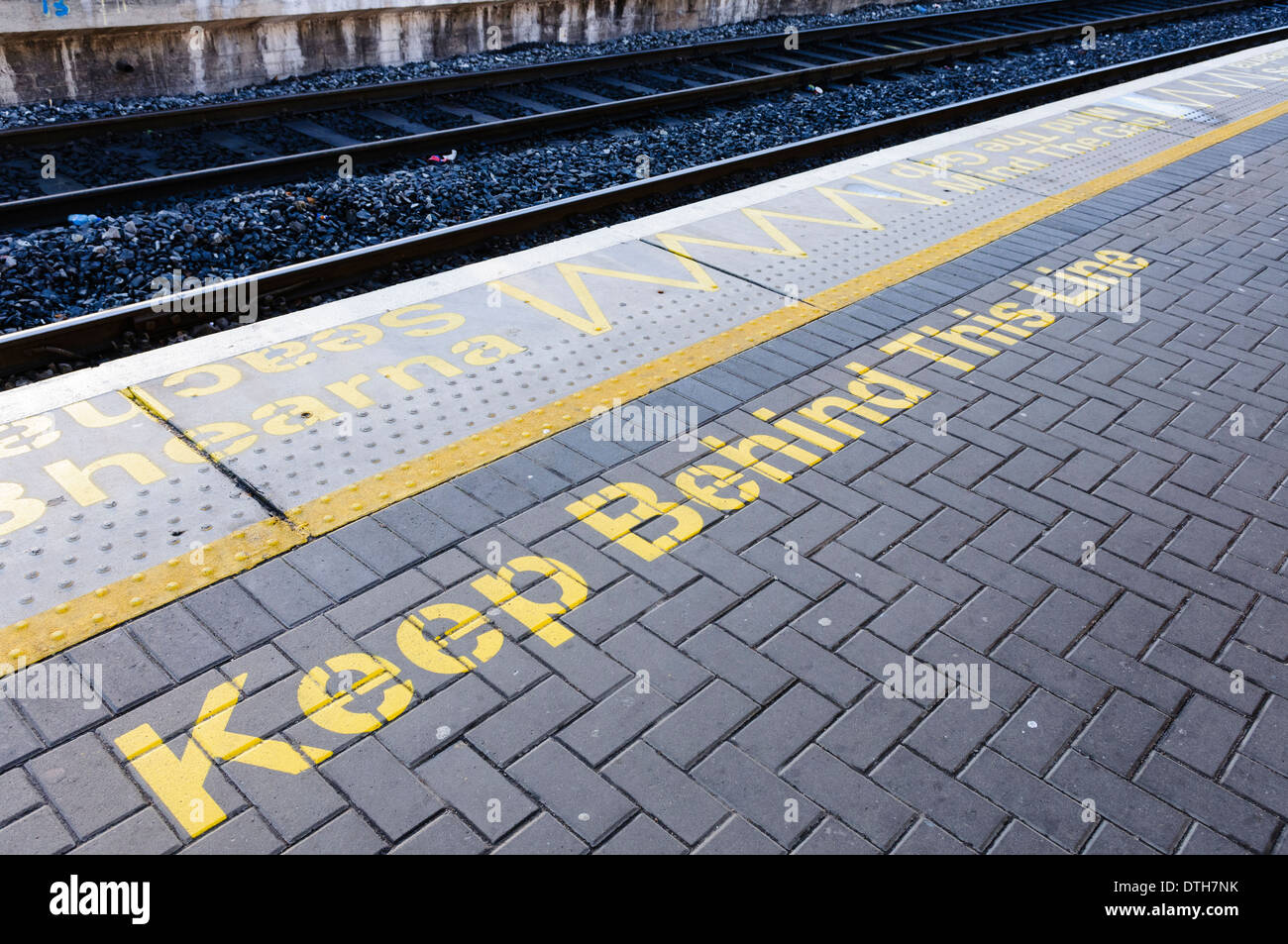 'Tenere dietro questa linea' su una piattaforma ferroviaria Foto Stock