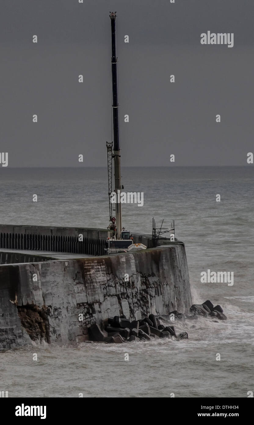 Newhaven, Sussex, Regno Unito. 18 febbraio 2014. Violazioni in West arm parete esterna può essere chiaramente visto. Proseguimento dei lavori di riparazione sarà possibile solo se le tempeste non ritorno. L'integrità dell'ora di proprietà francese struttura è cruciale per Newhaven Harbour operazioni come il braccio protegge l'ingresso. È stato costruito nel 1880. Credito: David Burr/Alamy Live News Foto Stock