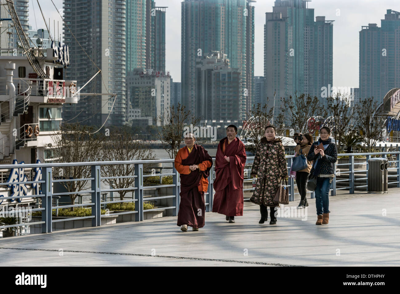 I monaci e i turisti a piedi lungo il Bund, Shanghai, Cina Foto Stock