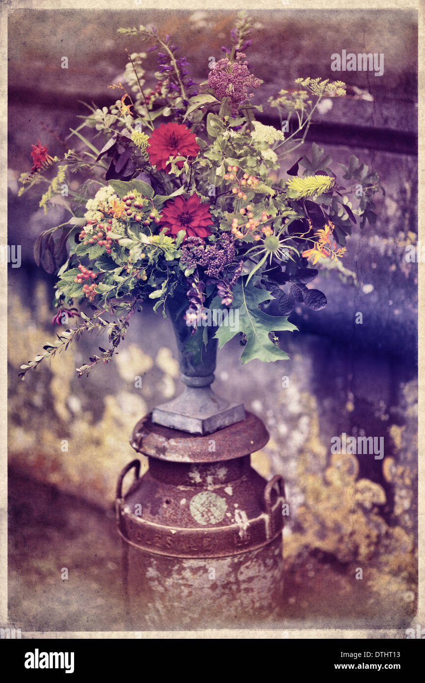 Rustico addobbi floreali sulla posizione in un giardino murato Foto Stock