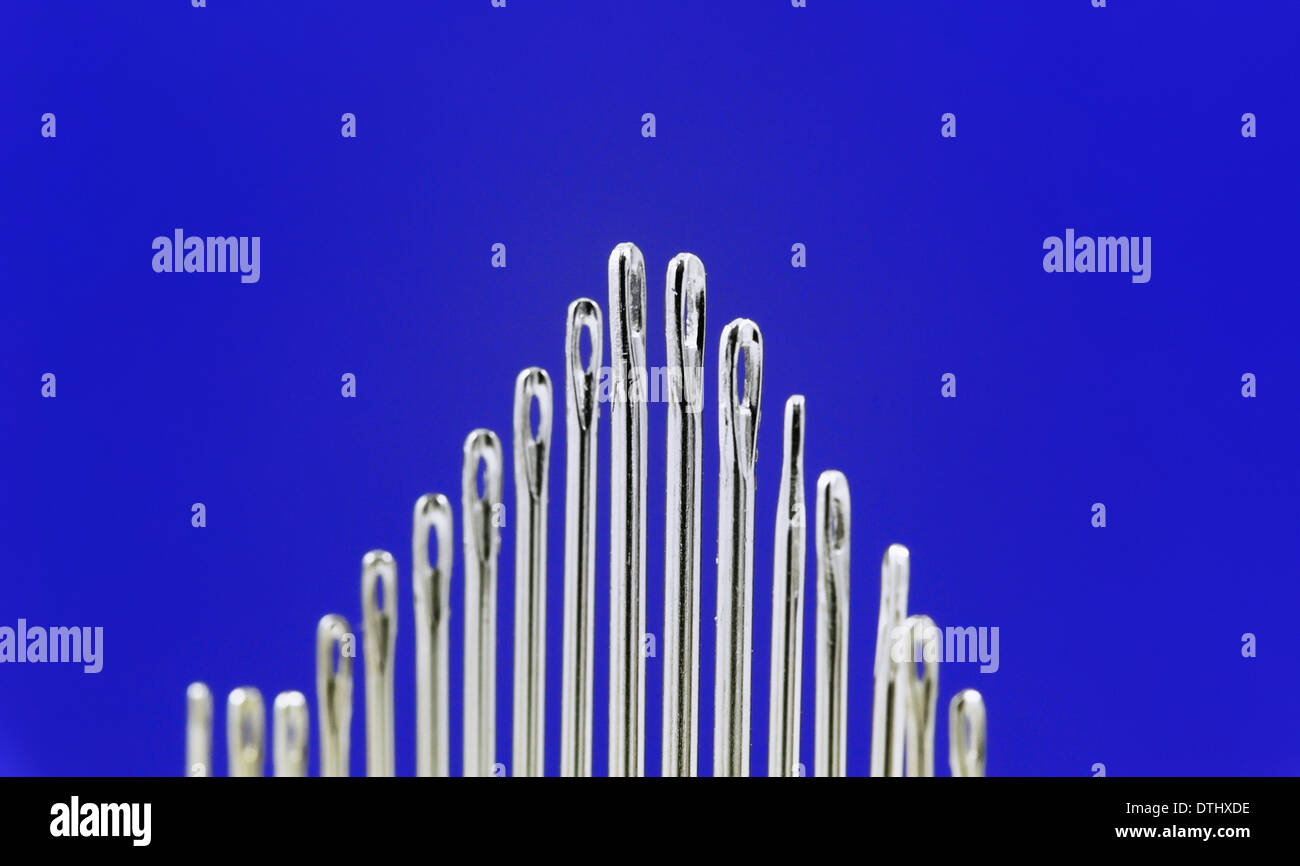 Aghi da cucire su uno sfondo blu Foto Stock