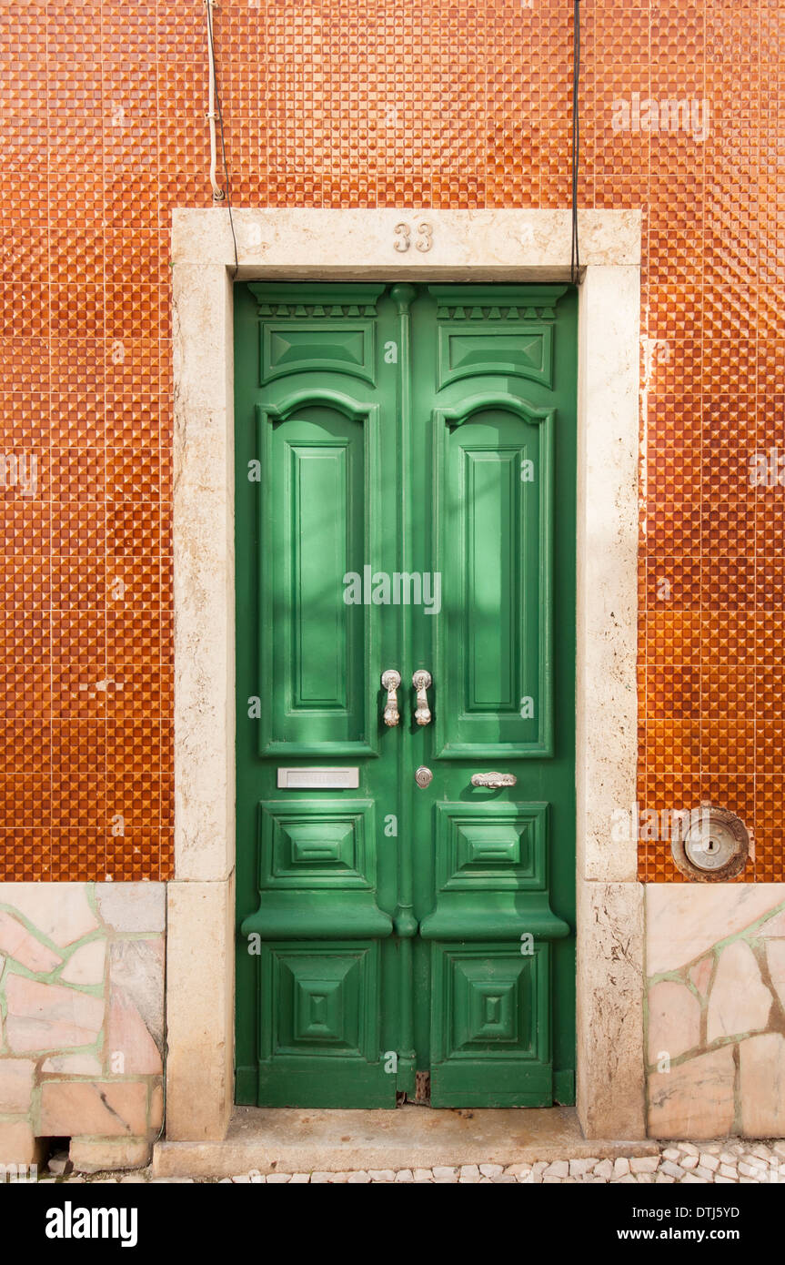 Bella tradizionali porta verde in una parete piastrellata, loghi, algarve, portogallo Foto Stock