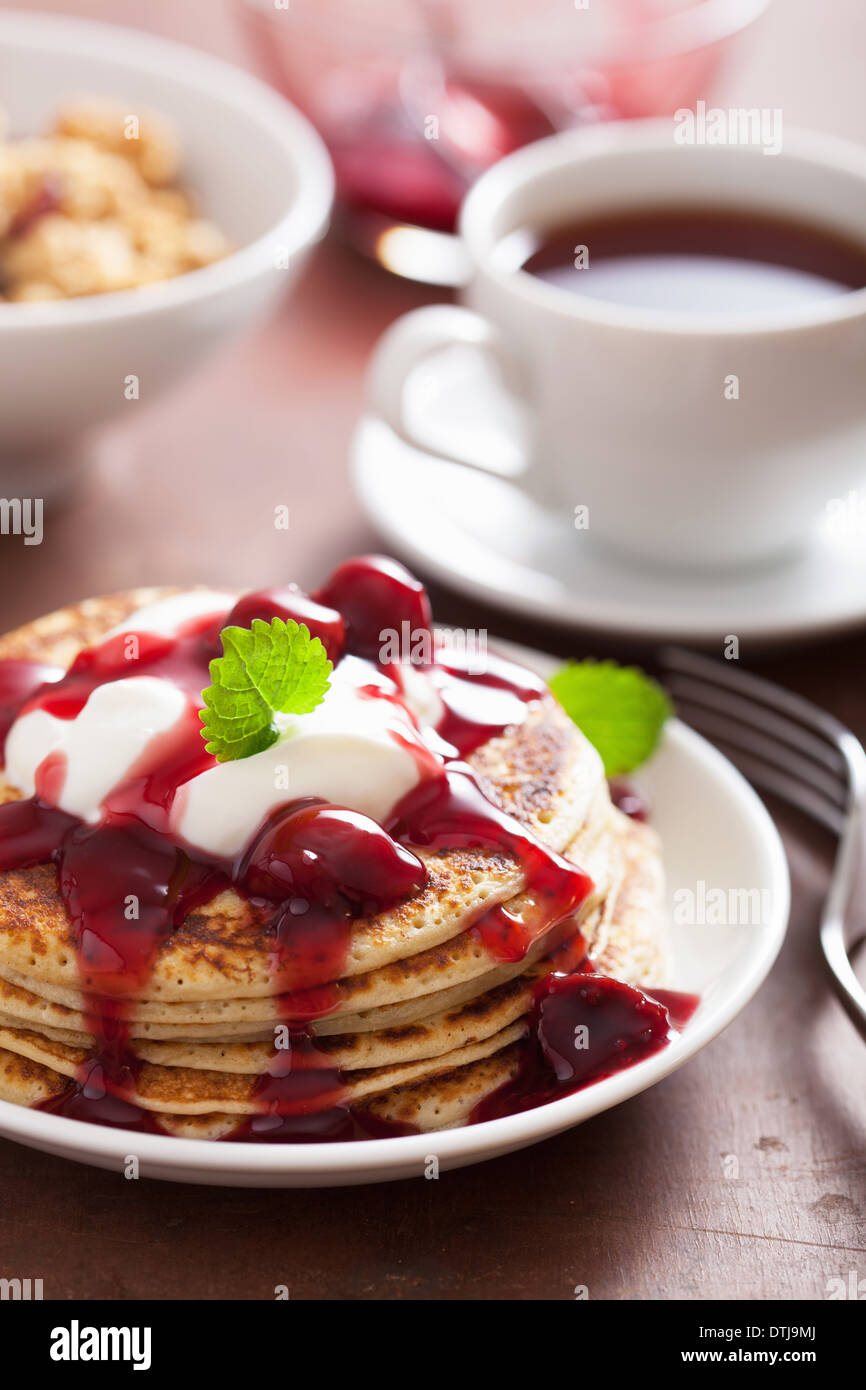 Frittelle con marmellata di ciliege e crema per la prima colazione Foto Stock