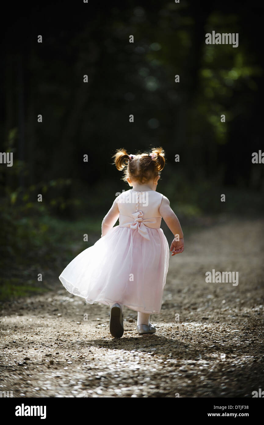 Bambino di scappare dalla fotocamera floaty rosa speciale damigella abito capelli rossi pigtail Foto Stock