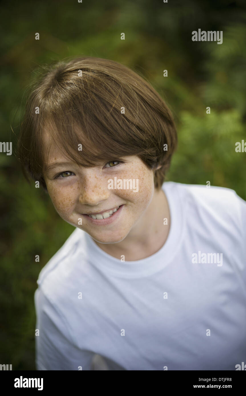 Un ragazzo in un bianco tee-shirt osservando la telecamera Hampshire Inghilterra Foto Stock