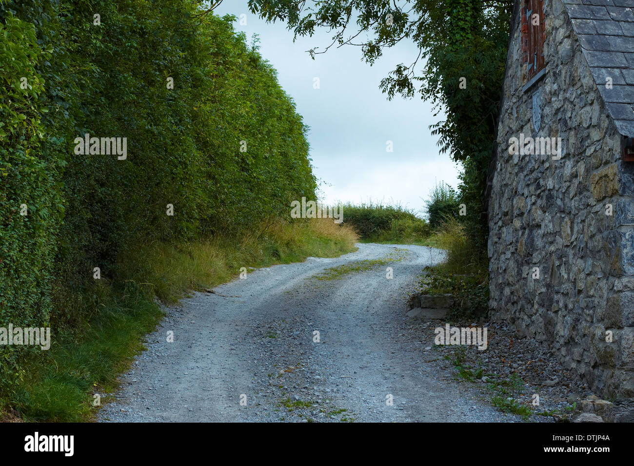 Strada tra casa di pietra e copertura in Irlanda Foto Stock