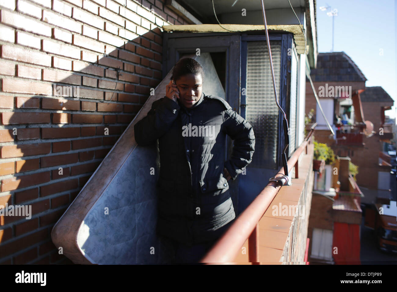 Madrid, Spagna. 19 feb 2014. 29 enne Maria Menendez Melendez parla attraverso il telefono presso la terrazza come ella attende di essere sfrattato dalla sua casa in Spagna a Madrid, mercoledì, 19 febbraio 2014. Maria Menendez Melendez 29 anni da Repubblica Dominicana ha vissuto per otto anni con il suo compagno Carlos e i loro due bambini, Raquel ConcepciÃƒÂ³n Menendez 9 anno-vecchio e Jean Carlos Concepcion Menendez 6 anno-vecchio, in un appartamento di proprietà di ''La camma -Sabadell'' con cui hanno contratto un mutuo che non hanno pagato per 6 anni.Prima di divenire disoccupati Maria ha lavorato come un kitchener Foto Stock