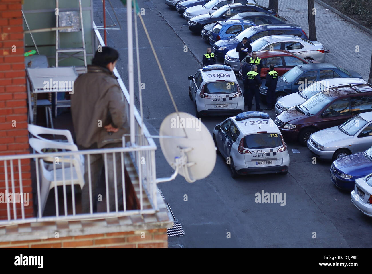 Madrid, Spagna. 19 feb 2014. Un vicino guarda alla polizia municipale che è venuto a sfrattare 29 enne Maria Menendez Melendez la famiglia durante il suo tentativo di sfratto di Madrid in Spagna, mercoledì, 19 febbraio 2014. Maria Menendez Melendez 29 anni da Repubblica Dominicana ha vissuto per otto anni con il suo compagno Carlos e i loro due bambini, Raquel ConcepciÃƒÂ³n Menendez 9 anno-vecchio e Jean Carlos Concepcion Menendez 6 anno-vecchio, in un appartamento di proprietà di ''La camma -Sabadell'' con cui hanno contratto un mutuo che non hanno pagato per 6 anni.Prima di divenire disoccupati Maria ha lavorato come Foto Stock