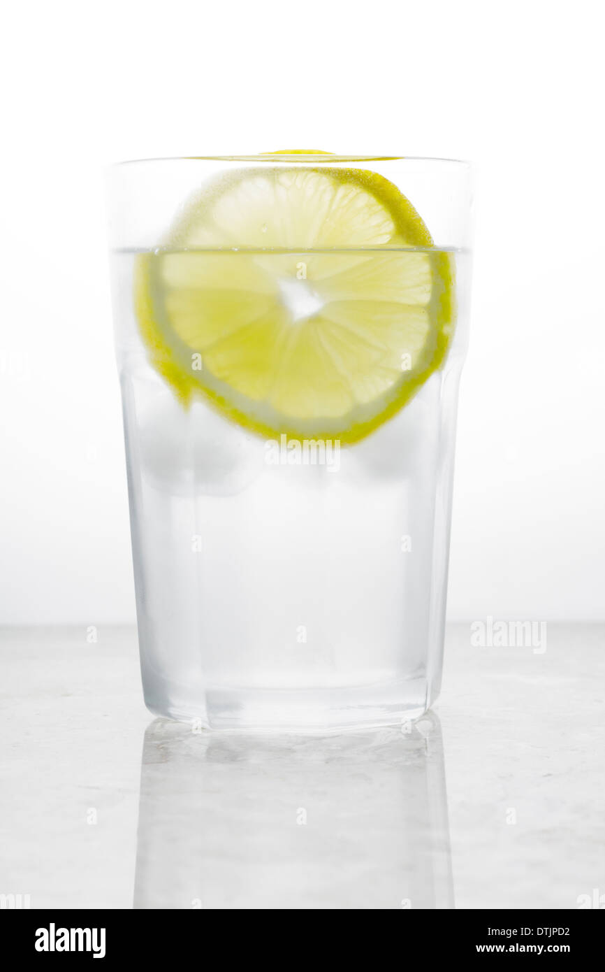 Bicchiere di acqua con ghiaccio e limone Foto Stock