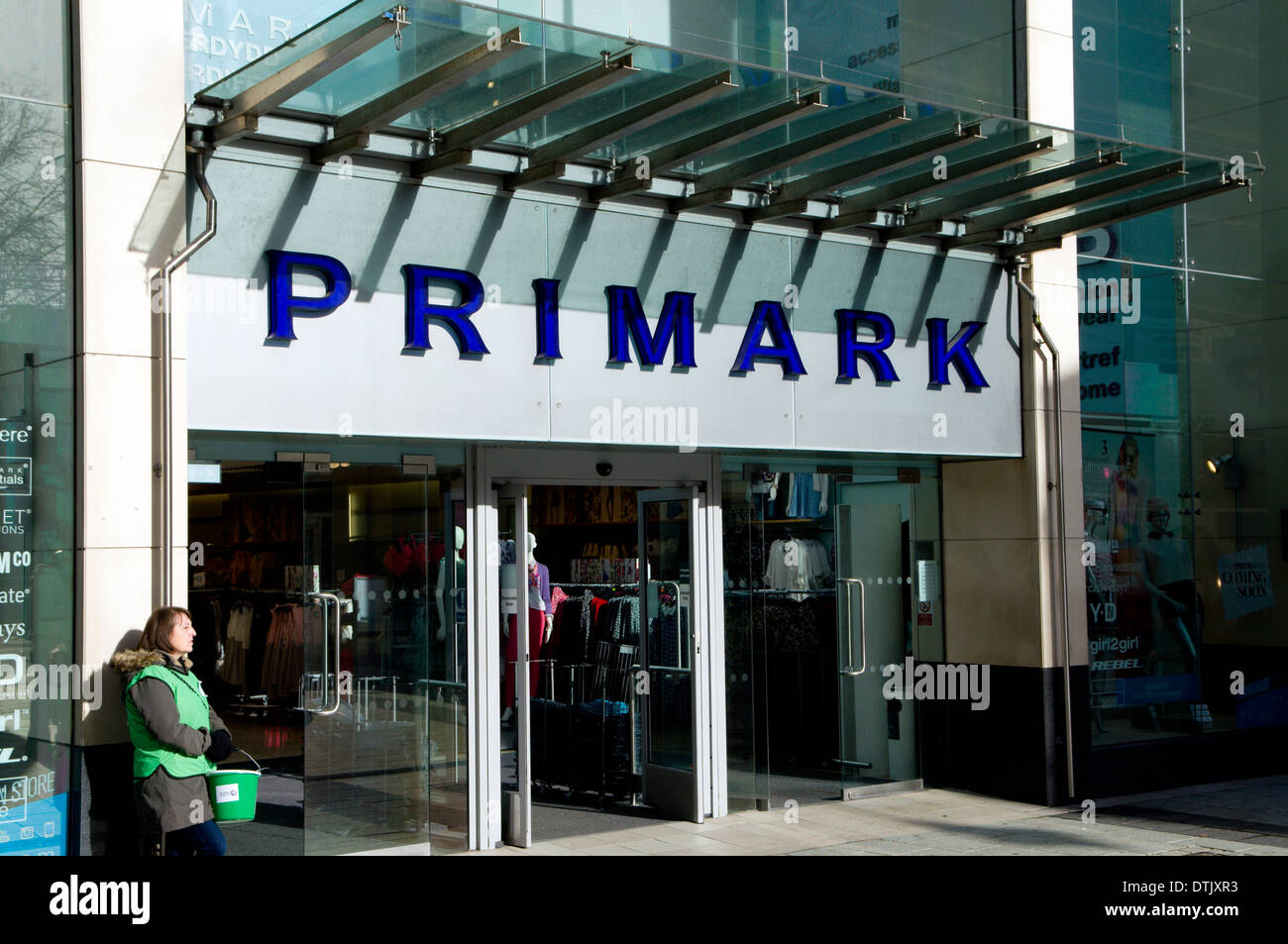 Primark shop e la donna per raccogliere per carità, Queen Street, Cardiff, Galles. Foto Stock