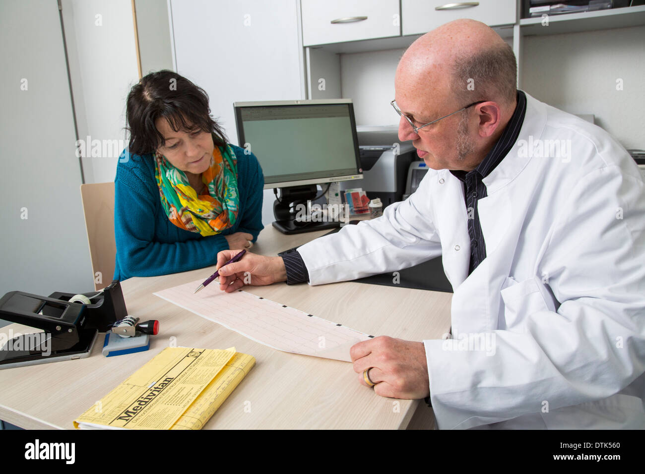 I medici in ufficio. Dottore spiega il risultato di un ECG esame cardiaco. Foto Stock