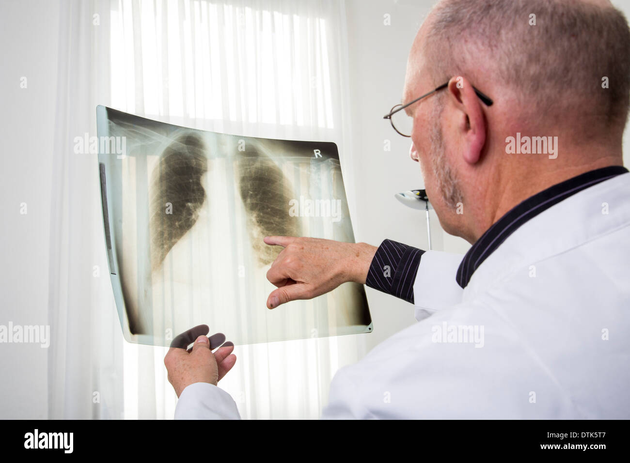 Medico guarda un'immagine a raggi x. Foto Stock