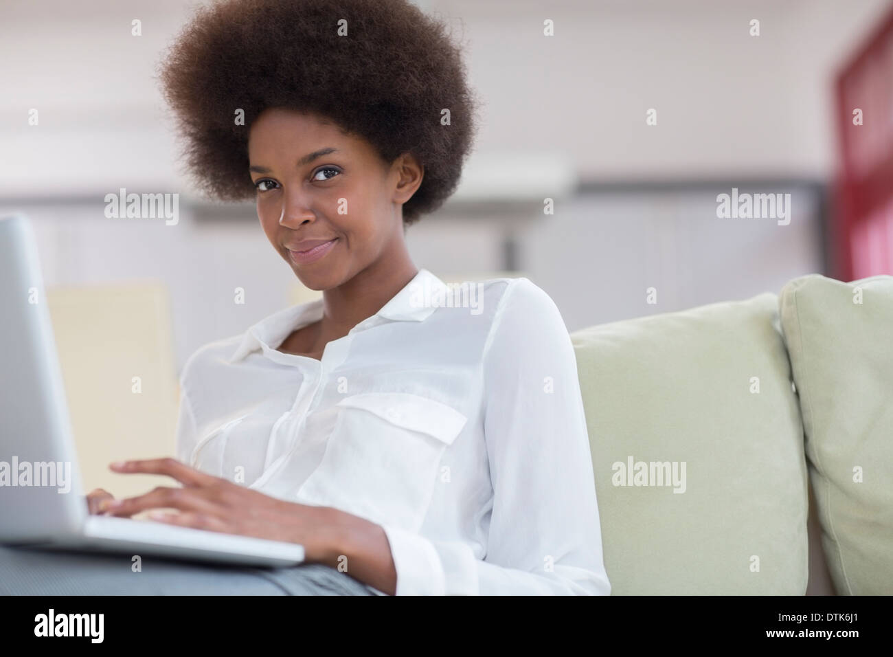 Imprenditrice utilizzando computer portatile sul divano Foto Stock