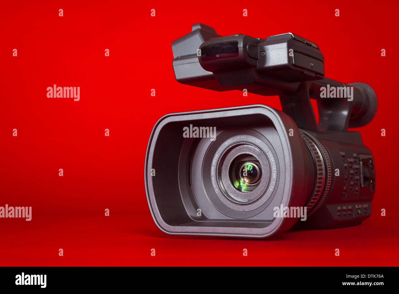 Un nero videocamera su uno sfondo rosso con spazio di copia Foto Stock