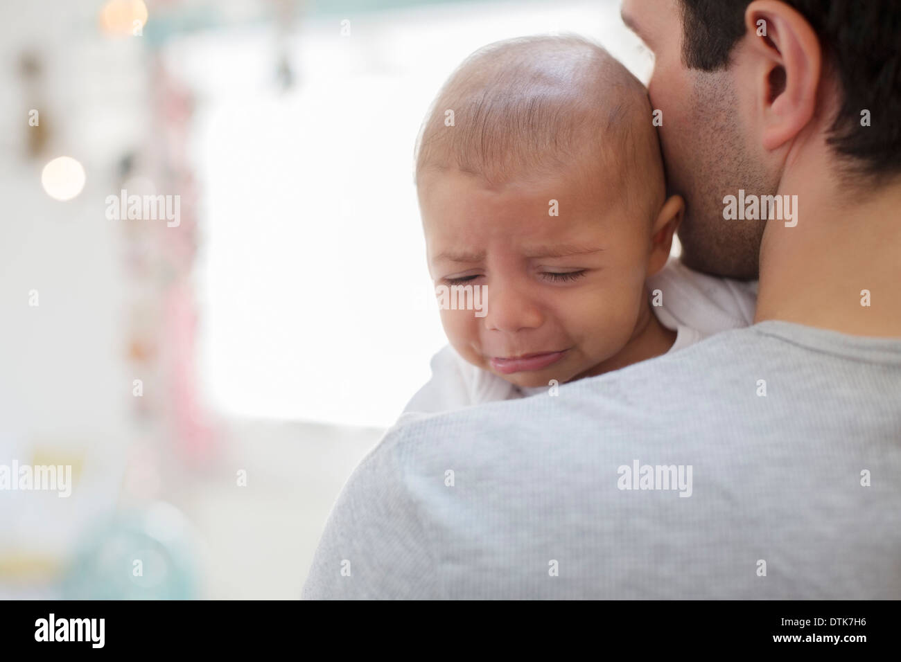 Padre tenendo il pianto baby boy Foto Stock