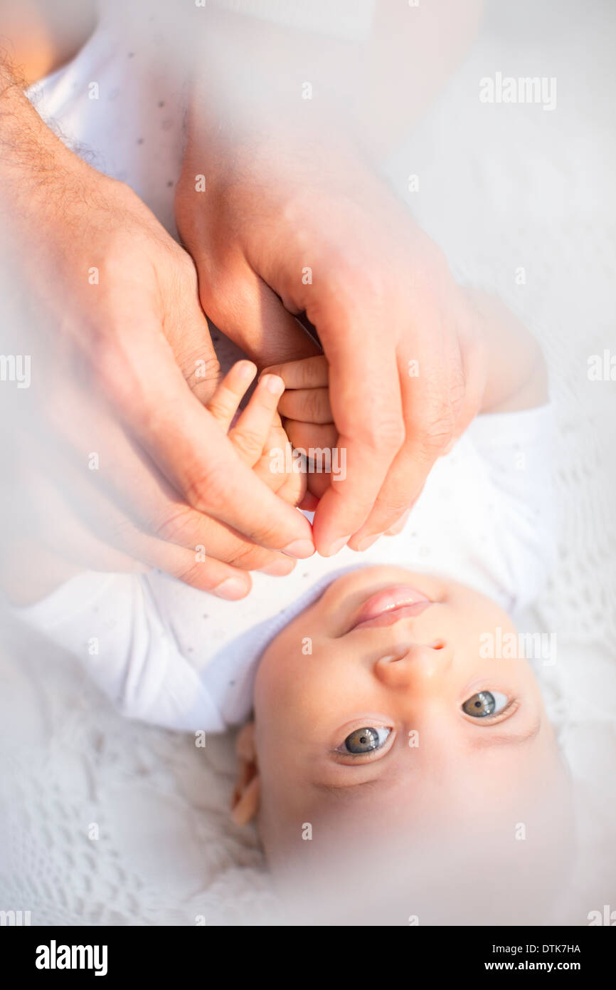 Padre holding baby boy le mani Foto Stock