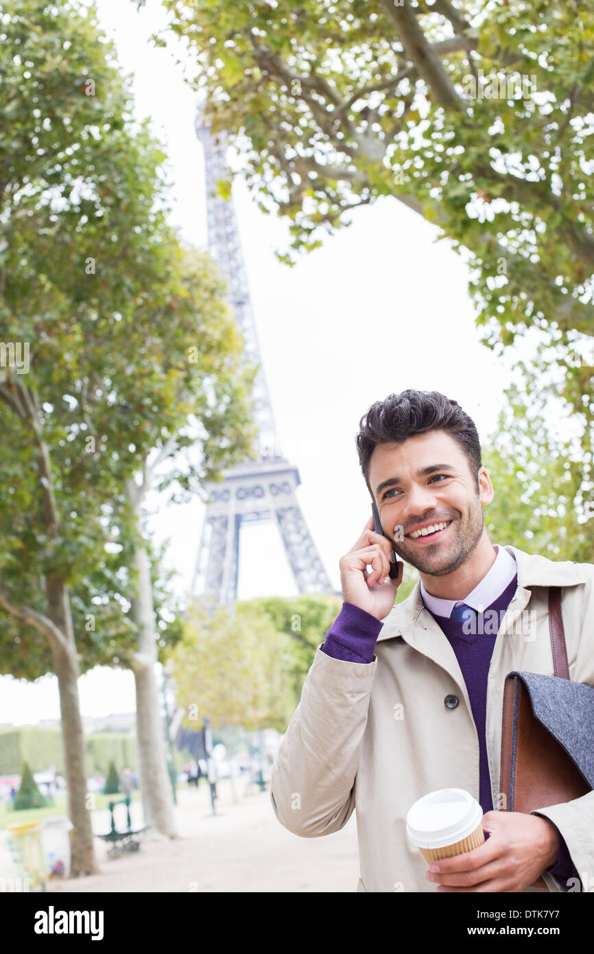 Imprenditore parlando al cellulare vicino alla Torre Eiffel, Parigi, Francia Foto Stock