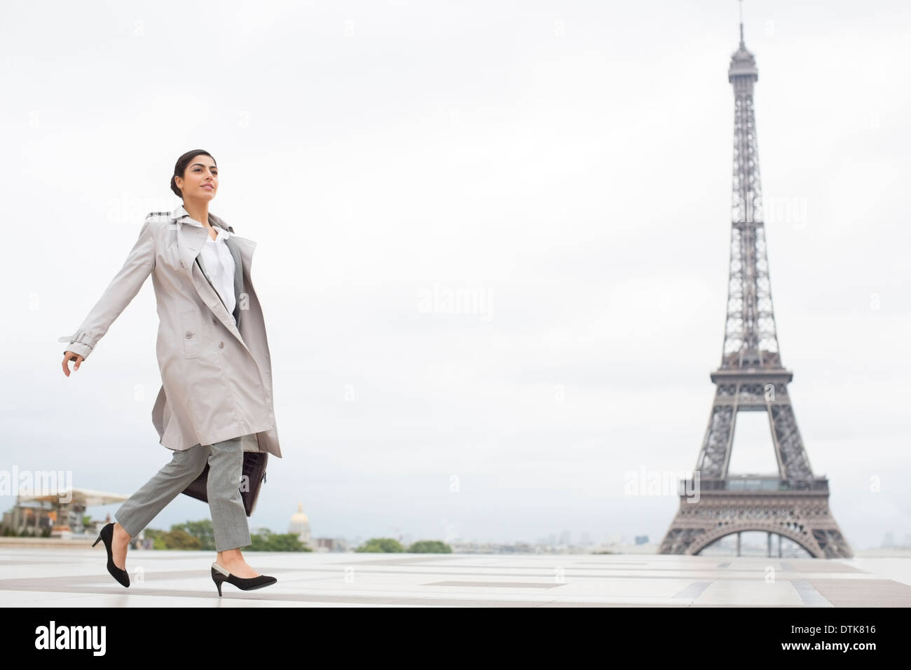 Imprenditrice camminare davanti alla Torre Eiffel, Parigi, Francia Foto Stock