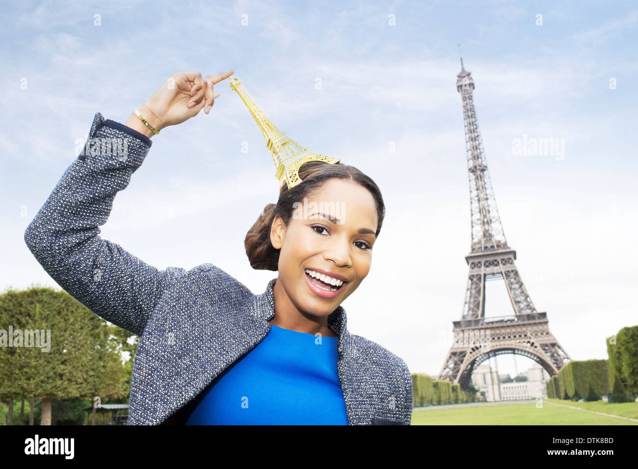 La donna posa con souvenir di fronte alla Torre Eiffel, Parigi, Francia Foto Stock