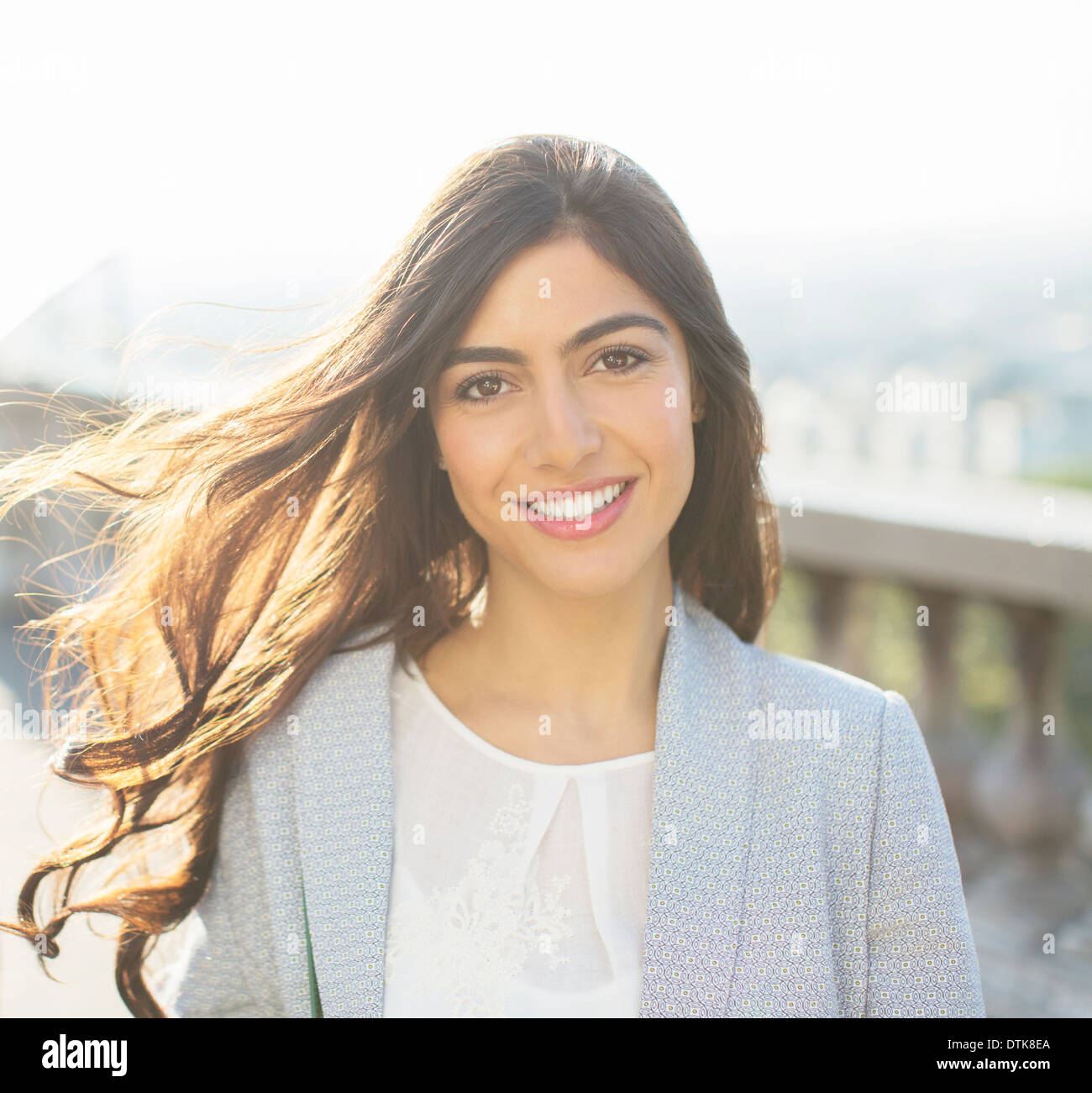 Vento capelli lunghi di donna sorridente all'aperto Foto Stock