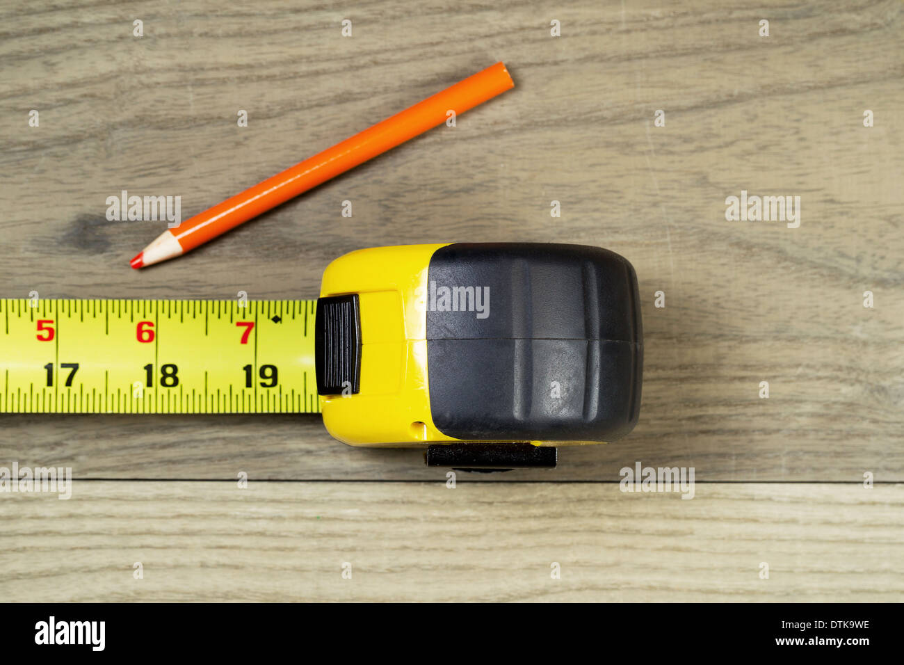 Foto orizzontale aperto di misura di nastro arancione e matita su legno invecchiato Foto Stock