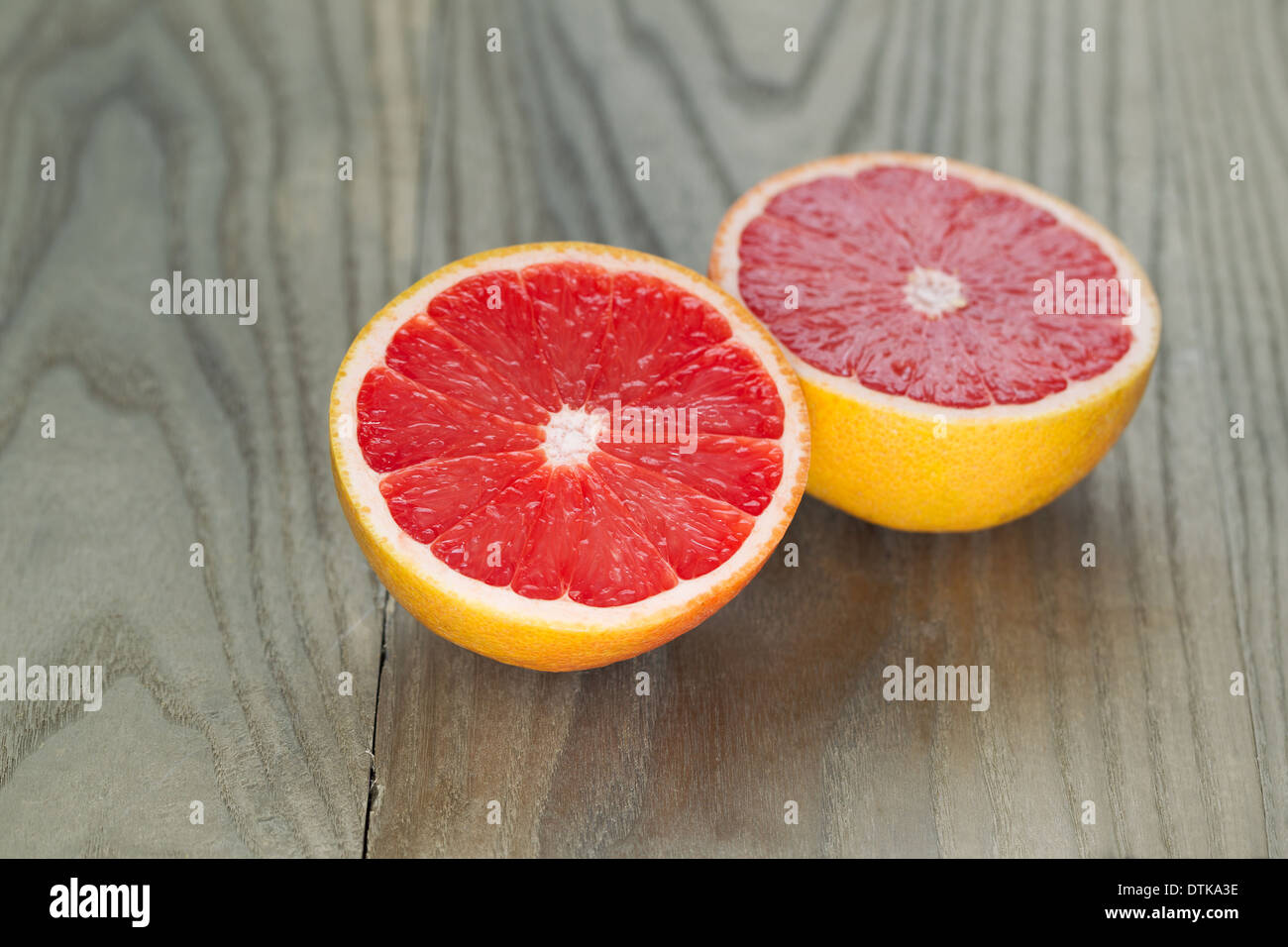 Foto orizzontale di fettine di ruby pompelmo rosso sul legno invecchiato Foto Stock