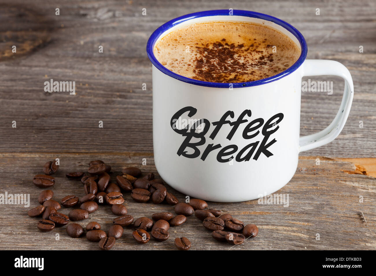 Tazze di smalto con caffè caldo e i chicchi di caffè su un rustico di legno con la parola "Pausa caffè" sulla tazza Foto Stock